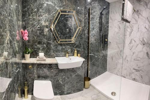 a bathroom with a sink and a shower at Milestone Cottage in Swansea