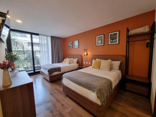 a hotel room with two beds and a window at Condesa Cibel in Mexico City