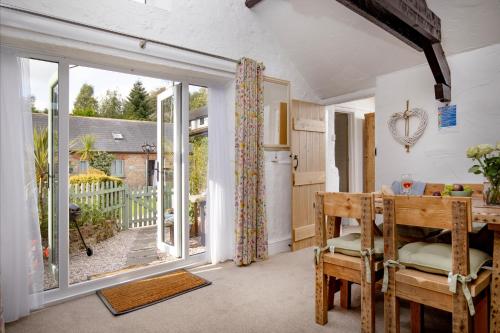 a dining room with a table and a large window at Jasmine Cottage in Paignton