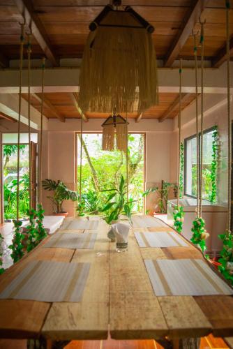 a large wooden table in a room with windows at The Temple III, Mindo in Mindo