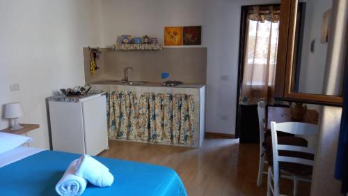 a kitchen with a table and a sink in a room at Le casette di Simona in Lampedusa