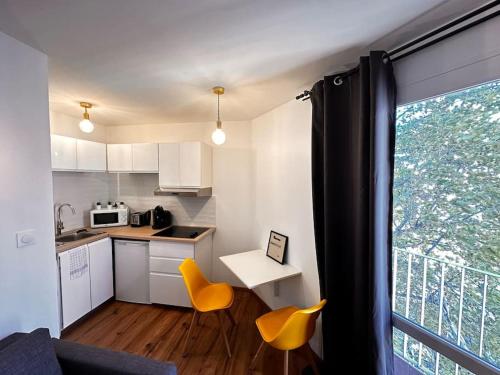 une cuisine avec une table et des chaises et une fenêtre dans l'établissement Charmant Studio Moderne et lumineux 1min gare, à Marseille
