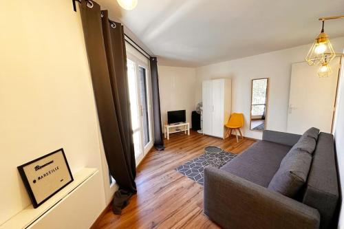 un salon avec un canapé et une fenêtre dans l'établissement Charmant Studio Moderne et lumineux 1min gare, à Marseille
