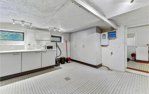 an empty kitchen with white cabinets and a window at Nice Home In Spjald With 6 Bedrooms in Videbæk