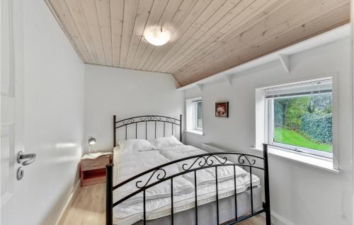 a bedroom with a black bed and a window at Nice Home In Spjald With 6 Bedrooms in Videbæk