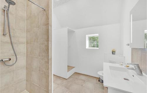 a white bathroom with a shower and a toilet at Nice Home In Spjald With 6 Bedrooms in Videbæk