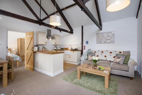 a kitchen and a living room with a couch and a table at Daisy Cottage in Paignton