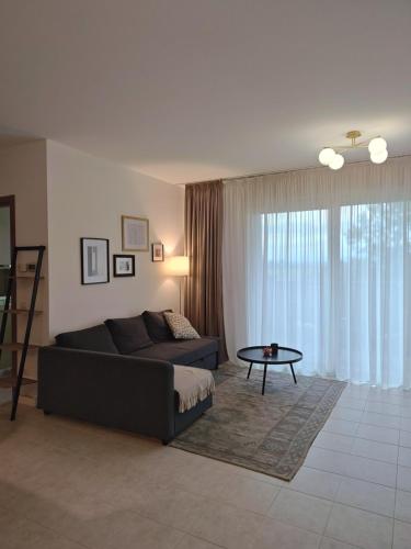 a living room with a couch and a table at Sunset Penthouse in Gessate