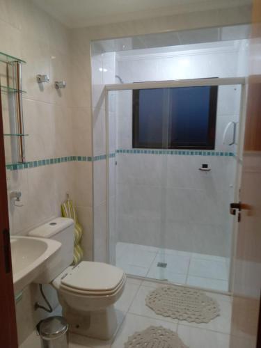 a bathroom with a shower and a toilet and a sink at Piemonte Flat Apart in Serra Negra