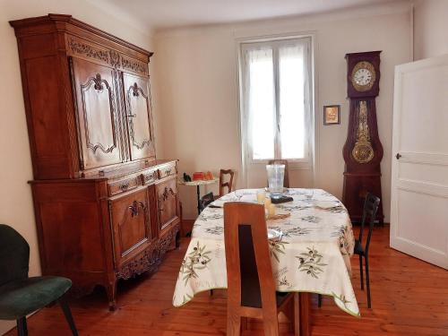 un comedor con una mesa y un gran armario de madera en Les Sables d'Olonne - Arago - Le 16, en Les Sables-dʼOlonne