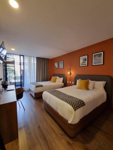 a hotel room with two beds and a desk at Condesa Cibel in Mexico City
