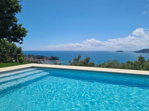 a swimming pool with a view of the ocean at "Quercia House", inside a Private Park, shared Pool, Tennis, AC, Parking next home and a Garage in Lerici! in Lerici