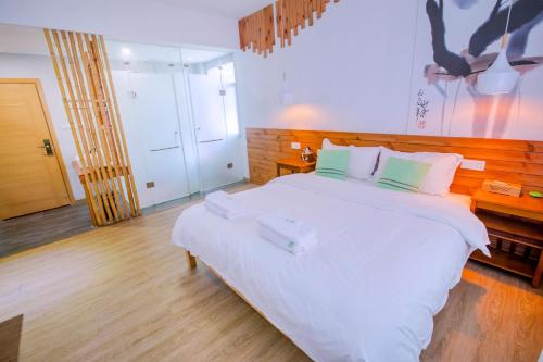 a bedroom with a large white bed in a room at Zhangjiajie Forest Park Youth Hostel in Zhangjiajie