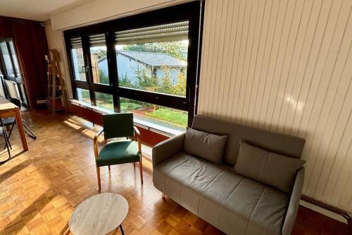 un salon avec un canapé et une grande fenêtre dans l'établissement La Corniche, à Thonon-les-Bains