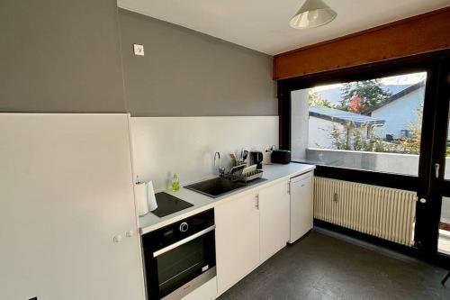 une petite cuisine avec un évier et une fenêtre dans l'établissement La Corniche, à Thonon-les-Bains