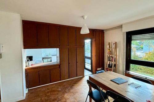 a dining room with a table and a kitchen at La Corniche in Thonon-les-Bains
