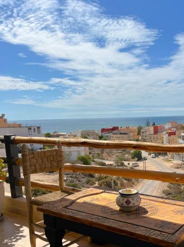 a balcony with a table and a view of the ocean at Monza Surf House in Tamraght Ouzdar