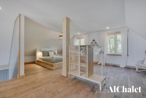 a bedroom with a bed and a crib in a room at Shack saison - vue sur le fleuve avec spa in Petite-Rivière-Saint-François