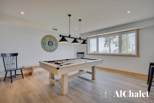 a room with a ping pong table and a window at Shack saison - vue sur le fleuve avec spa in Petite-Rivière-Saint-François