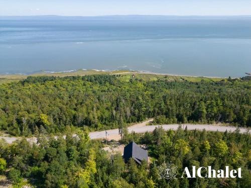 an aerial view of a forest with a building on a hill at Shack saison - vue sur le fleuve avec spa in Petite-Rivière-Saint-François