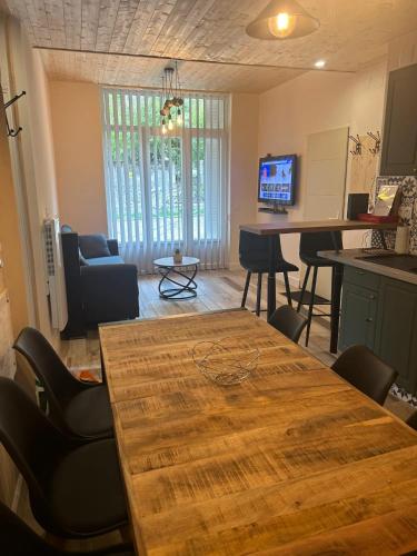 a living room with a wooden table and chairs at Appartement charmant à Savignac-les-Ormeaux, 56 m², balcon in Savignac-les-Ormeaux