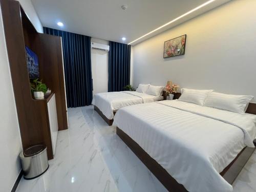 a hotel room with two beds in it at La Vita Hotel in Ấp Bàu Bàng