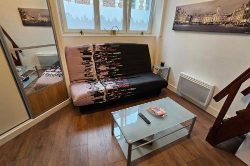 un salon avec un canapé et une table dans l'établissement Old Arras studio avec mezzanine, à Arras