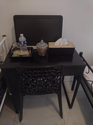 - une table noire avec une bouteille d'eau et un panier dans l'établissement Le Brossolette 2, à Saint-Denis