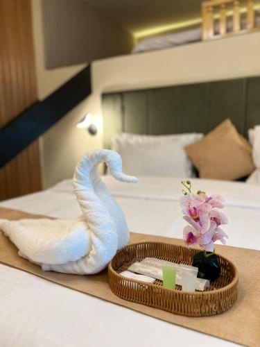 a towel and a tray with a towel swan on a bed at Ortus - Murree Hills in Murree
