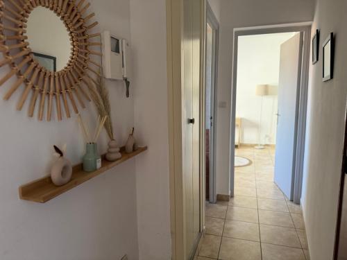 un couloir avec un miroir mural et un couloir avec une porte dans l'établissement Le botaniste, à Perpignan