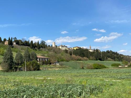 a field of grass with houses on a hill at Il Podestà in Laterina