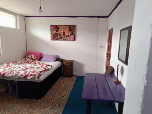 Un dormitorio con una cama y una mesa dentro. en Dede Sebo Çay Bahçesi + Camping, en Doğubayazıt