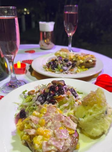 two plates of food on a table with wine glasses at Finca Hotel Santa Clara in Calarcá