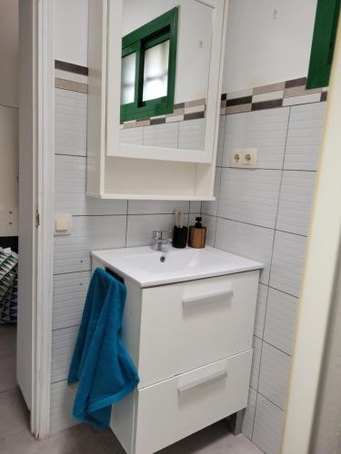 a white bathroom with a sink and a mirror at VV Sweet Flamboyan Playaflor 1 "by henrypole home" in Maspalomas