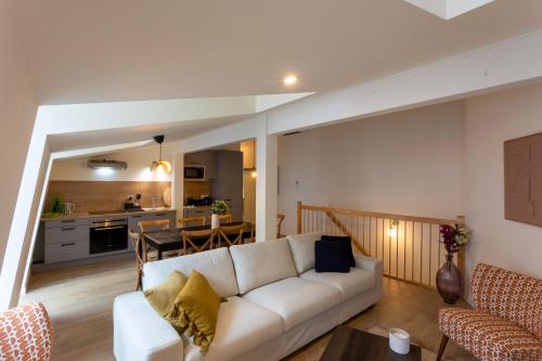 un salon avec un canapé blanc et une cuisine dans l'établissement Urban Loft, à Toulouse