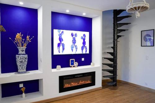 a living room with a fireplace and a blue wall at La Majorelle du Palais des Papes in Avignon