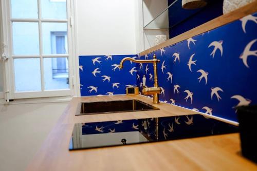 a bathroom with a sink and a blue wall at La Majorelle du Palais des Papes in Avignon