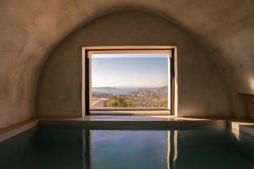 a room with a window and a pool of water at Aethra Vegan Caves in Pirgos