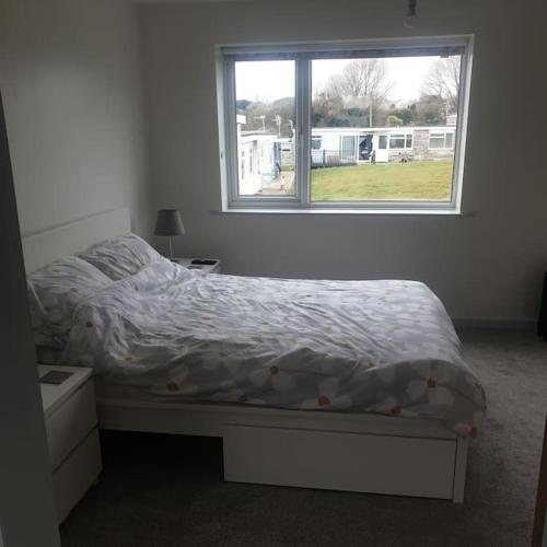 a bedroom with a bed and a window at 112 Sandown Holiday Park, Wifi, sleeps 4 in Sandown