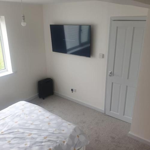 a bedroom with a bed and a tv on the wall at 112 Sandown Holiday Park, Wifi, sleeps 4 in Sandown