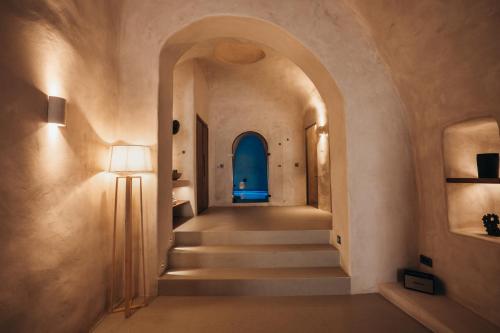 a hallway with a blue door and stairs at Aethra Vegan Caves in Pirgos