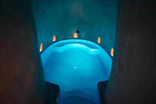 a blue table in a dark room with lights at Aethra Vegan Caves in Pirgos