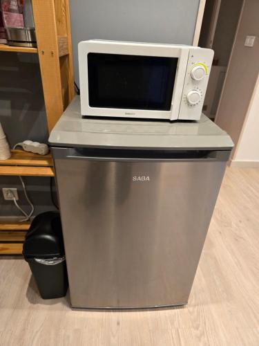 un micro-ondes posé sur un réfrigérateur dans l'établissement Chambre privée à 10min de Roissy CDG, au Calme, Parking gratuit, au Mesnil-Amelot