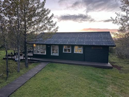 a small house in a field with a yard at Cabin in Vaðnes in Selfoss