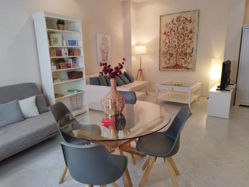 a living room with a glass table and chairs at Alleanza, Suite Cathedral, Private Rooftop in Seville