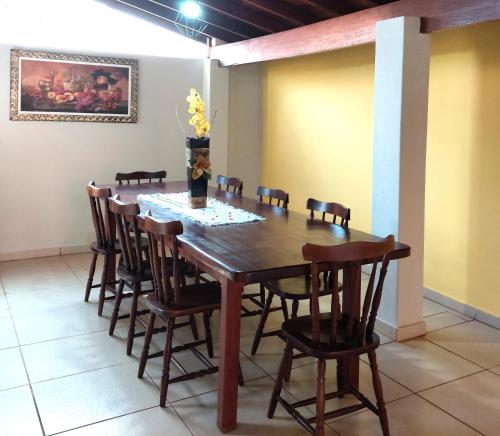 a wooden table and chairs in a room at Temporada Belas Casas in São Pedro