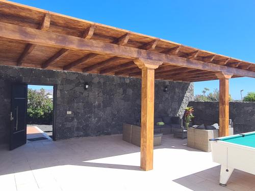 pérgola de madera con mesa de billar en el patio en Villa Carla, en Playa Blanca