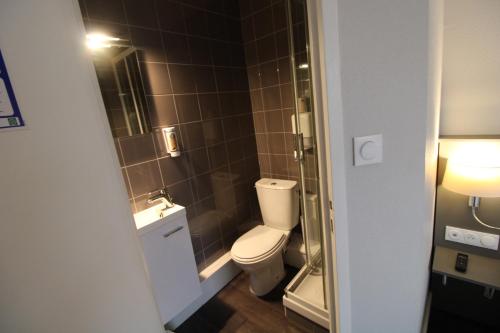 a bathroom with a toilet and a sink at Hôtel Casabianca in Moulins