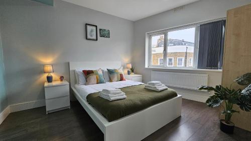 a bedroom with a bed and a large window at Charming Chalk Farm Properties in London