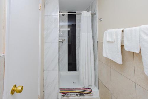 a bathroom with a shower with white towels at Budget Inn Columbus in Lockbourne
